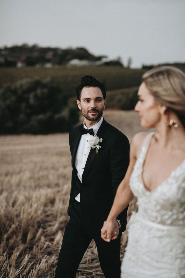 Groom wearing tailored suit looking at his bride in Adelaide
